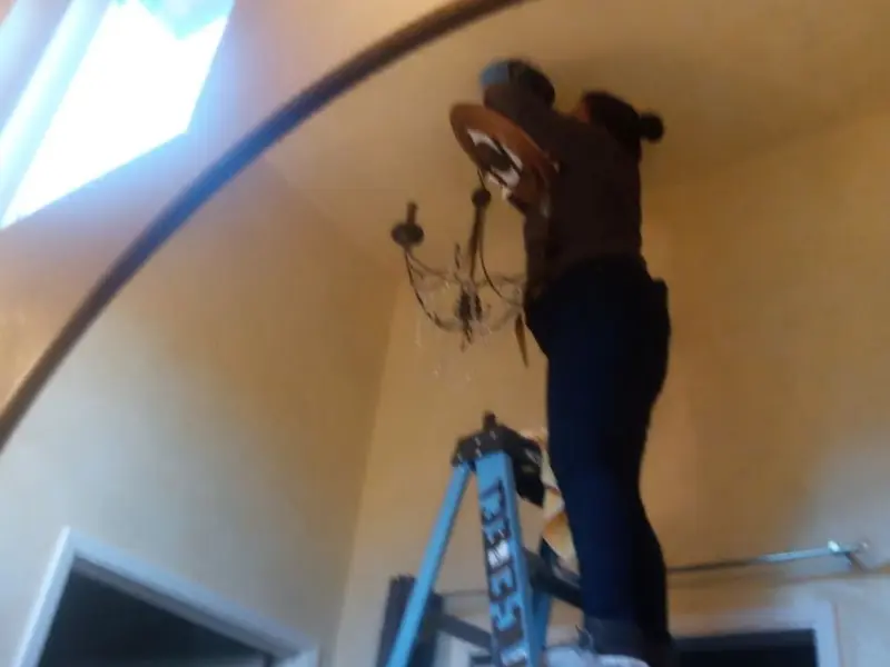 Electrician installing a chandelier in a Ulysses residence